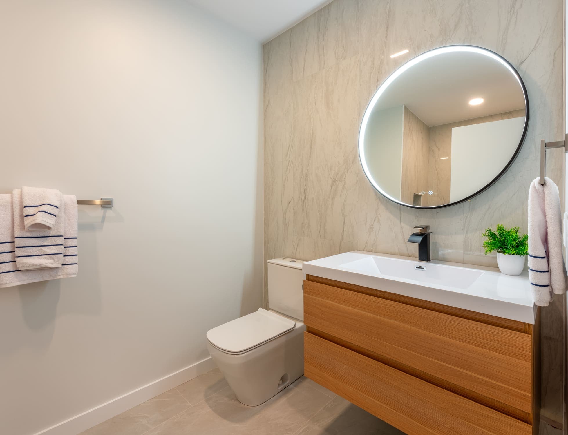 A restroom with a sink, a mirror and a toilet