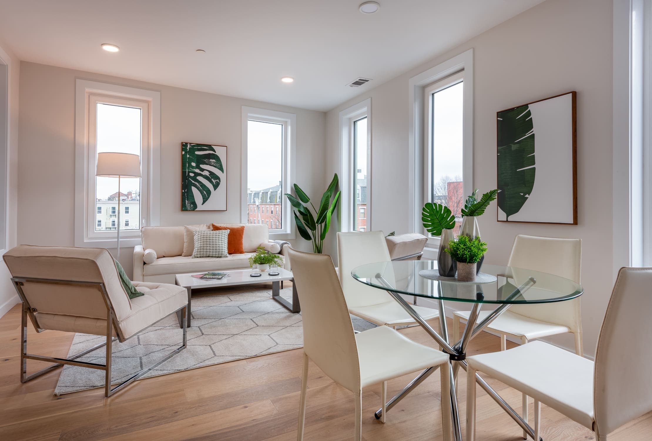 Living room diagonal view with four people table, sofas and armchairs