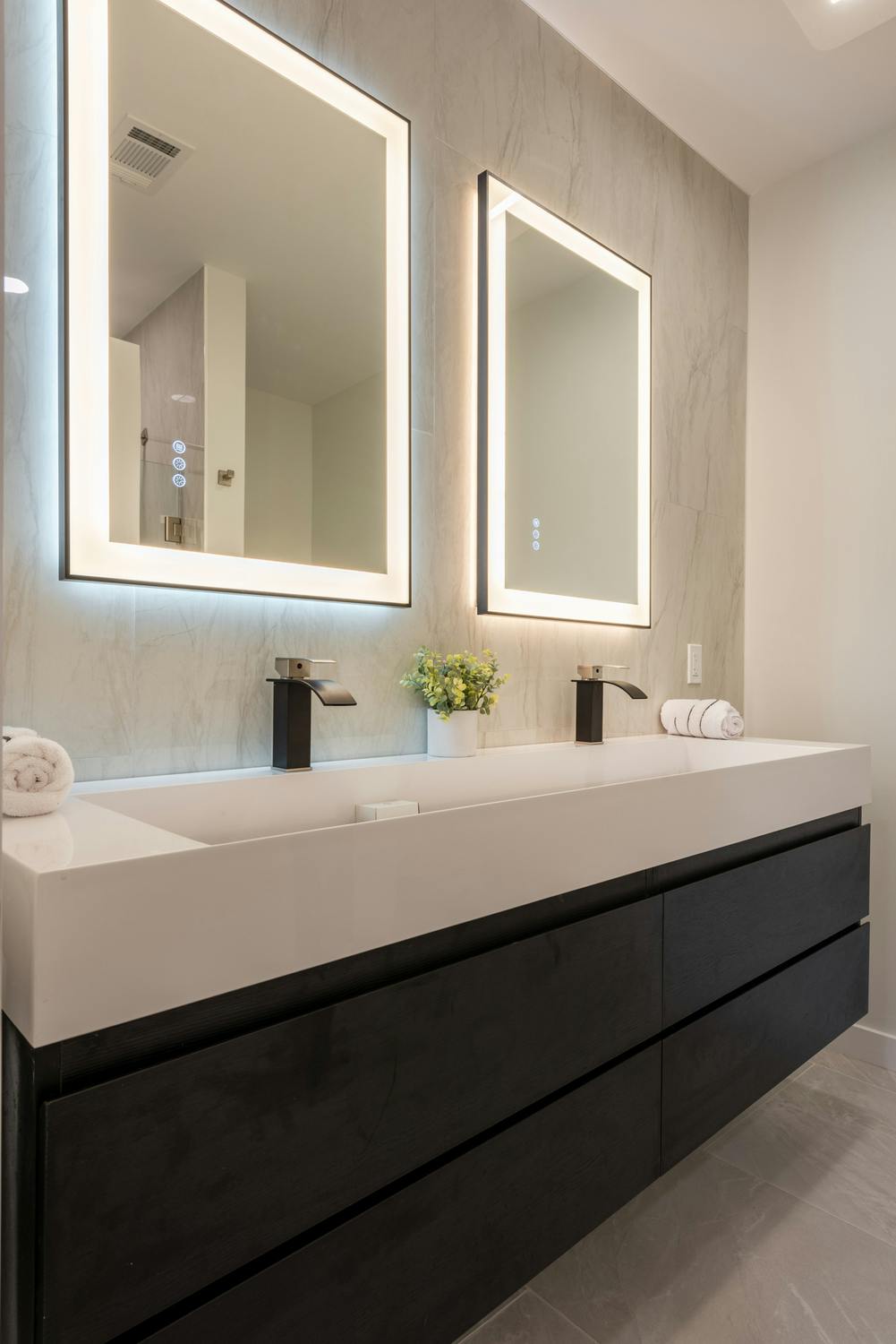 Bathroom with two sinks, two mirrors and cabnets